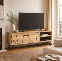Meuble TV Loftora en bois de manguier massif avec portes à motifs géométriques noirs et pieds en métal dans un salon