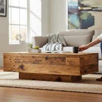 Table basse Loftora rectangulaire en bois massif effet vieux bois avec socle central dans un salon chaleureux